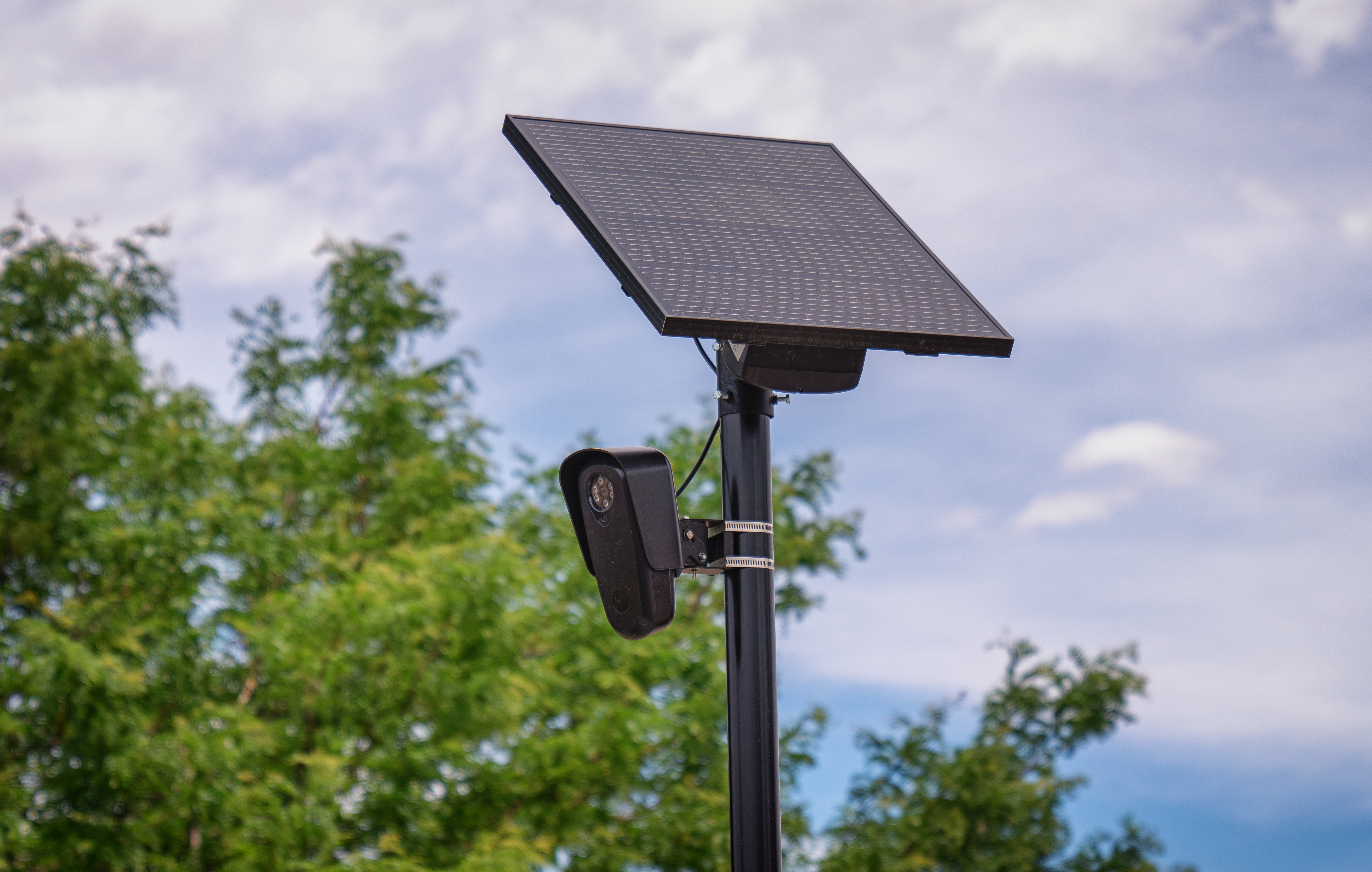 A Flock Safety license plate reader mounted below a solar panel in Aurora, Colorado.